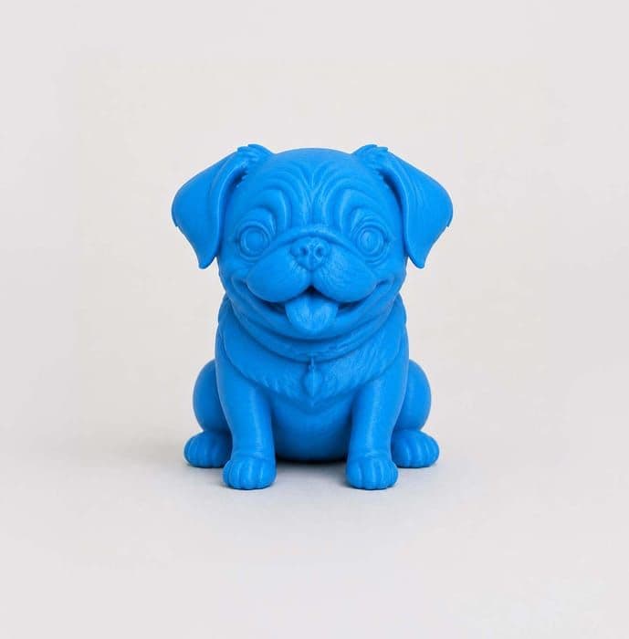 The blue 3D printed Pug figurine facing forward, sitting