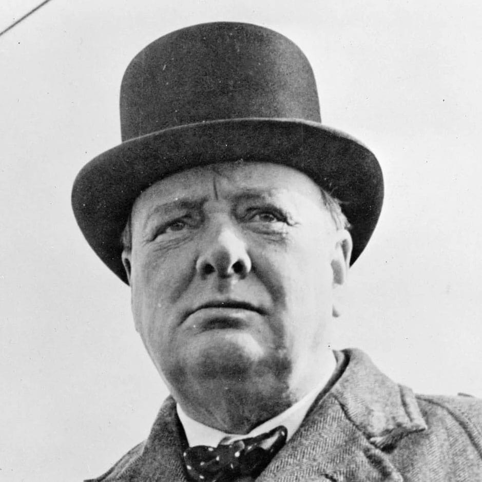 A black-and-white portrait photograph of a man in a top hat and polka-dot bow tie.